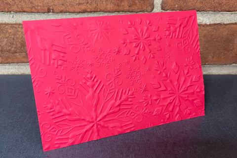 red paper card with snowflake design