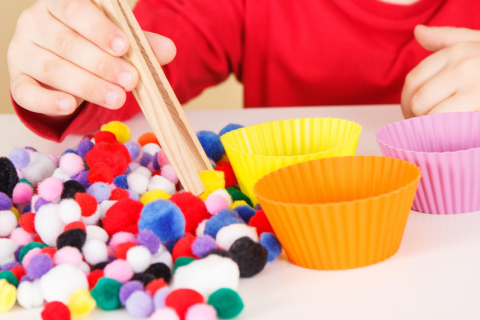sensory activity of moving pom poms into containers