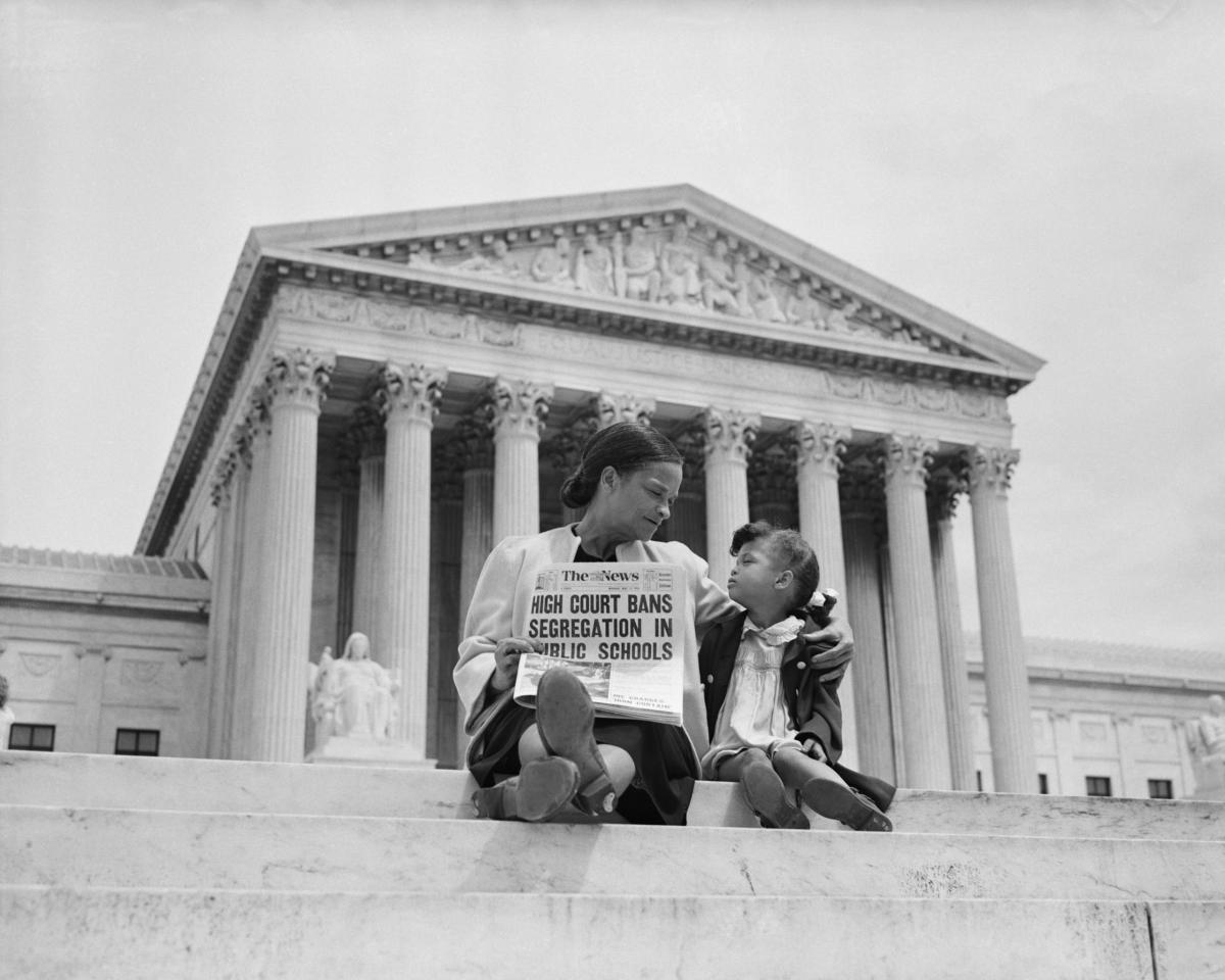 Black woman, girl on US Supreme Court steps holding newspaper; headline "High Court Bans Segregation in Public Schools"